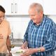 Opiekunka pomaga seniorowi w kuchni
